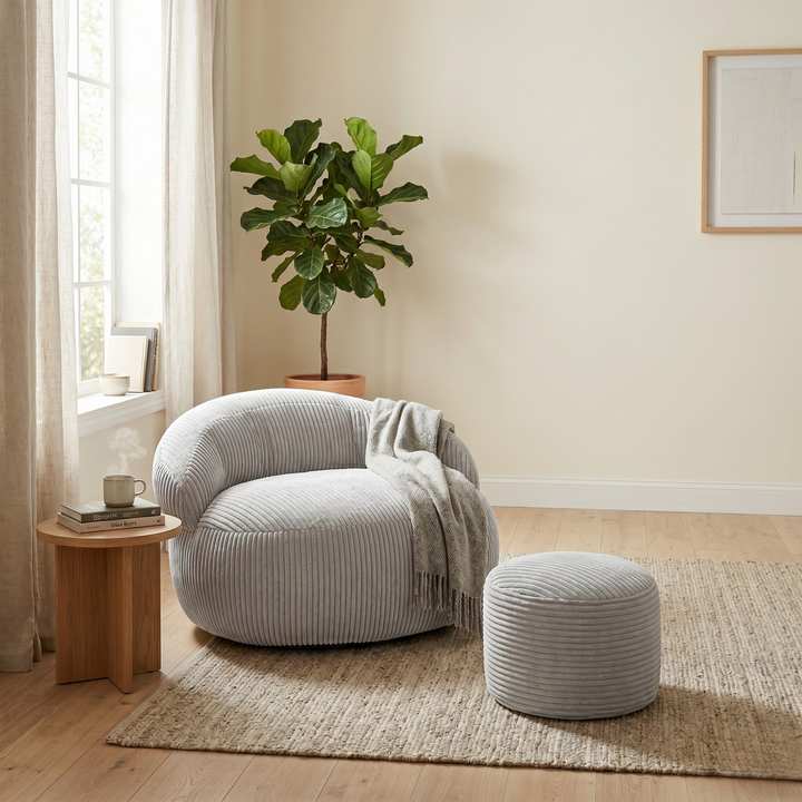 Pouf XXL velours côtelé rond avec repose-pieds assorti, dans un salon.