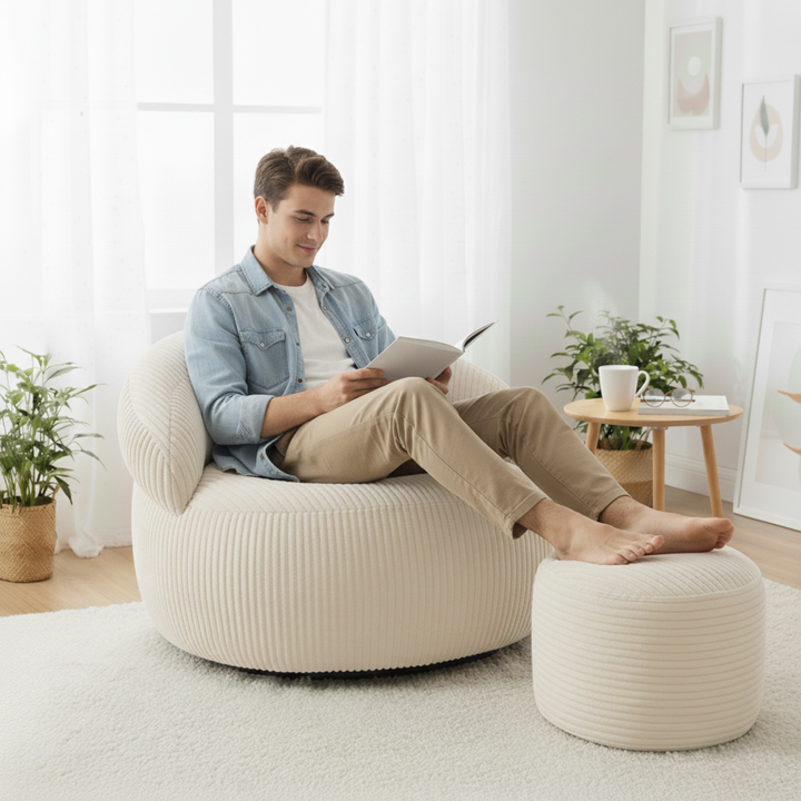 Personne assise confortablement sur un pouf XXL en velours côtelé avec repose-pieds, dans un salon