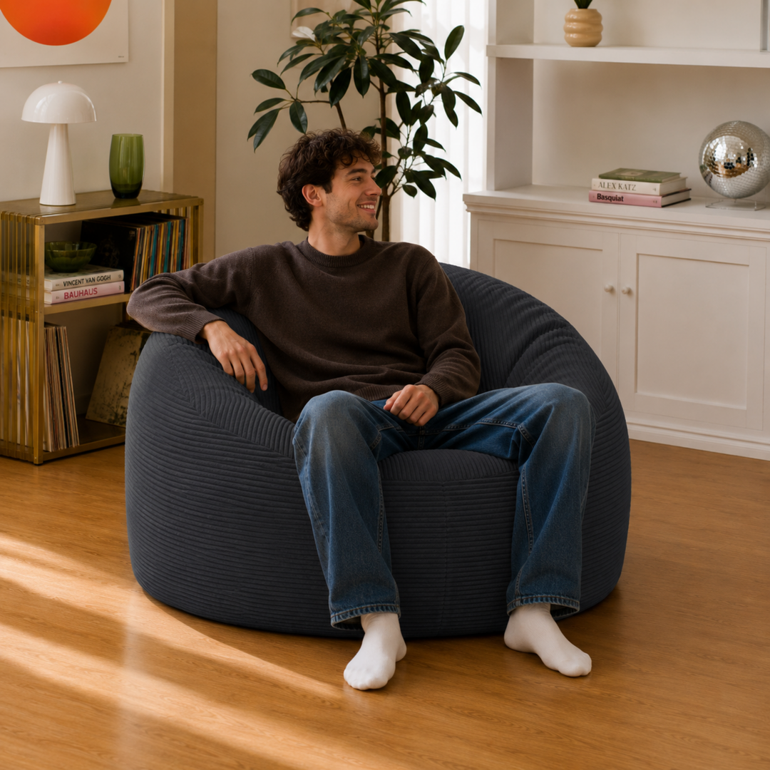 Homme assis sur un pouf déhoussable 100 cm en velours côtelé épais, gris foncé