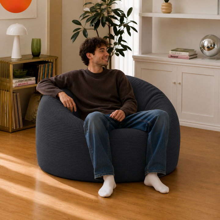 Homme assis sur un pouf déhoussable 100 cm en velours côtelé épais, gris foncé