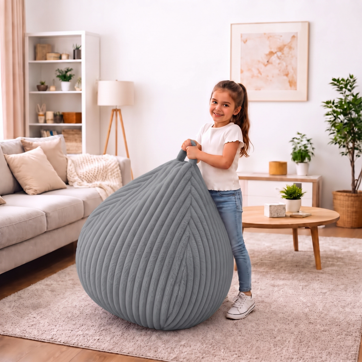 Personne tenant un pouf poire fourrure côtelée par les poignées intégrées