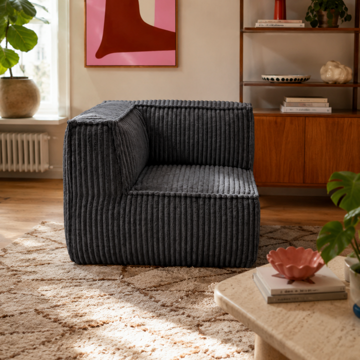Module d’angle en velours côtelé gris foncé, assise avec accoudoir, dans un salon